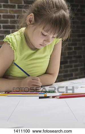 Girl drawing at table against brick wall in house View Large Photo Image Stock Image - Girl drawing at table against brick wall in house. Fotosearch