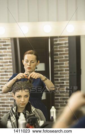 Hairdresser styling model's hair in studio View Large Photo Image Stock Image - Hairdresser styling model's hair in studio. Fotosearch