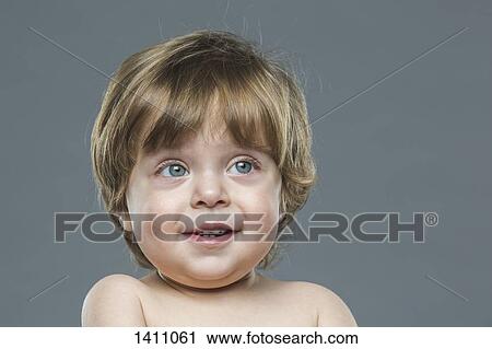 Happy boy looking away against gray background View Large Photo Image Stock Image - Happy boy looking away against gray background. Fotosearch