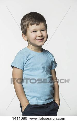 Happy boy standing with hands in pockets against white background View Large Photo Image Stock Image - Happy boy standing with hands in pockets against white background. Fotosearch