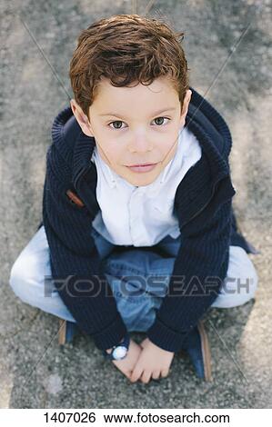 High angle portrait of boy sitting on street View Large Photo Image Stock Photograph - High angle portrait of boy sitting on street. Fotosearch