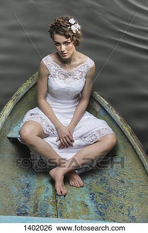 High angle portrait of sad young bride sitting in boat on lake View Large Photo Image Stock Photograph - High angle portrait of sad young bride sitting in boat on lake. Fotosearch