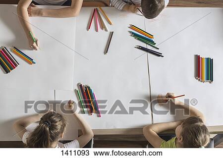 High angle view of children drawing on papers at table View Large Photo Image Stock Image - High angle view of children drawing on papers at table. Fotosearch