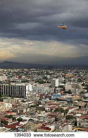 Stock Image - High angle view of cityscape against cloudy sky. Fotosearch