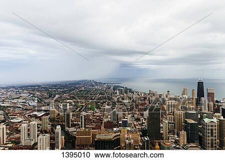 Stock Image - High angle view of cityscape against cloudy sky. Fotosearch
