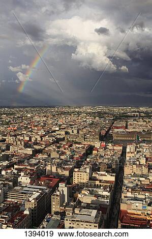 Stock Photo - High angle view of cityscape against cloudy sky. Fotosearch