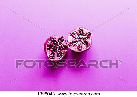 High angle view of pomegranate cut in half on pink background View Large Photo Image Stock Image - High angle view of pomegranate cut in half on pink background. Fotosearch