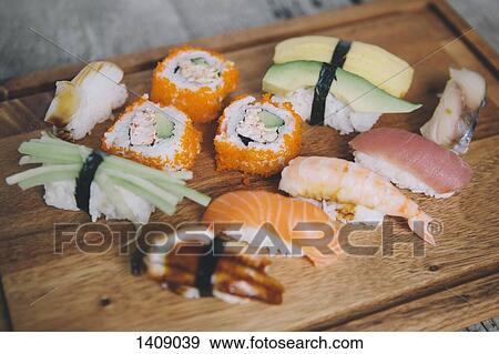 Stock Photo - High angle view of various sushi on cutting board. Fotosearch