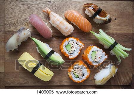 Stock Photography - High angle view of various sushi on cutting board. Fotosearch