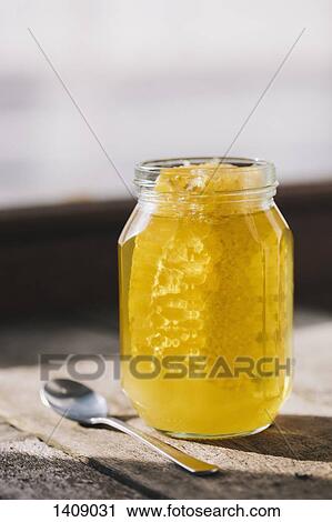 Honeycomb glass jar on table at home View Large Photo Image Stock Image - Honeycomb glass jar on table at home. Fotosearch