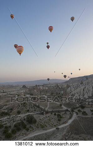 Hot air balloons flying over rocky landscape View Large Photo Image Stock Image - Hot air balloons flying over rocky landscape. Fotosearch