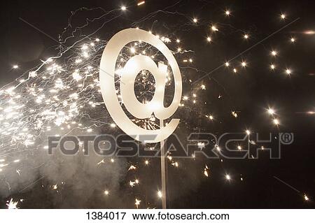 Illuminated at symbol with fireworks at night View Large Photo Image Stock Photo - Illuminated at symbol with fireworks at night. Fotosearch