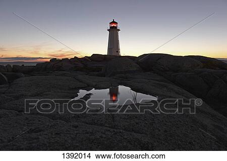 Lighthouse on rocky landscape against sky View Large Photo Image Picture - Lighthouse on rocky landscape against sky. Fotosearch