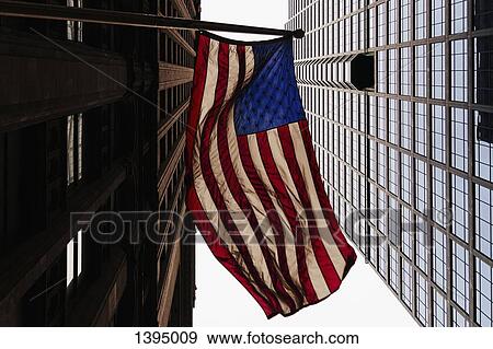 Stock Photo - Low angle view of American flag and office buildings. Fotosearch