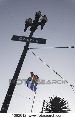 Stock Image - Low angle view of Castro street sign and rainbow flag against clear sky. Fotosearch