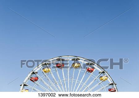 Low angle view of Ferris wheel against clear blue sky View Large Photo Image Stock Image - Low angle view of Ferris wheel against clear blue sky. Fotosearch