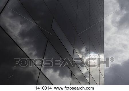 Low angle view of glass building against cloudy sky View Large Photo Image Picture - Low angle view of glass building against cloudy sky. Fotosearch