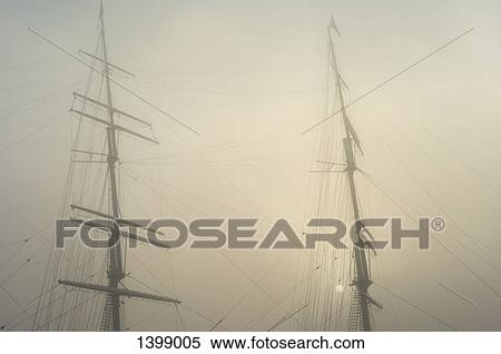 Stock Photography - Low angle view of masts against sky in foggy weather. Fotosearch