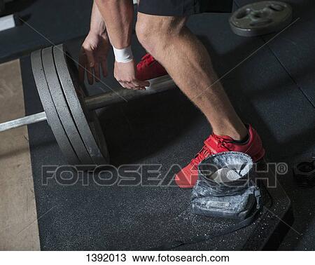 Low section of man with barbell in gym View Large Photo Image Stock Image - Low section of man with barbell in gym. Fotosearch