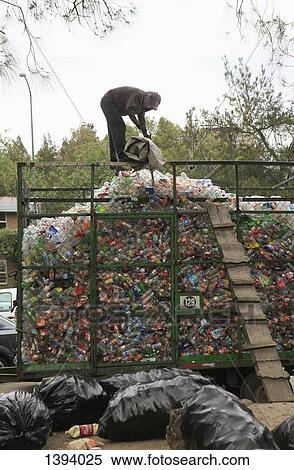 Stock Photography - Man working on heap of recyclable plastic waste at garbage dump. Fotosearch
