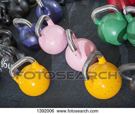Stock Photograph - Multi colored kettlebells in gym. Fotosearch