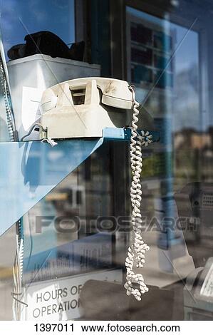 Stock Image - Old-fashioned telephone by glass wall. Fotosearch