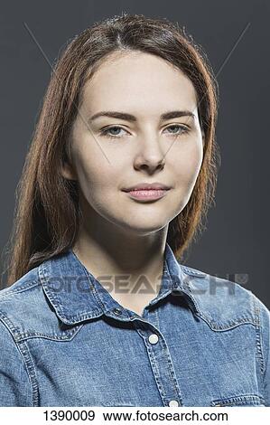 Portrait of beautiful young woman wearing denim jacket over gray background View Large Photo Image Stock Photo - Portrait of beautiful young woman wearing denim jacket over gray background. Fotosearch