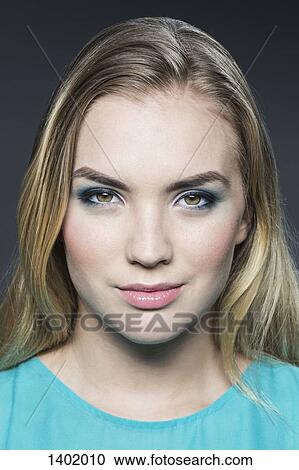 Portrait of beautiful young woman with blond hair over gray background View Large Photo Image Stock Image - Portrait of beautiful young woman with blond hair over gray background. Fotosearch