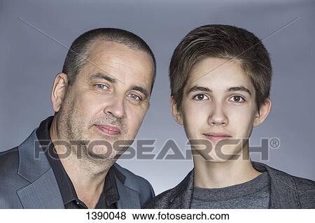 Portrait of confident father with son over gray background View Large Photo Image Stock Photo - Portrait of confident father with son over gray background. Fotosearch