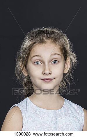 Stock Photo - Portrait of confident girl over gray background. Fotosearch