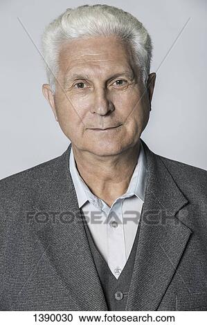 Stock Image - Portrait of confident senior man over gray background. Fotosearch