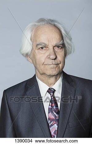 Picture - Portrait of confident senior man against gray background. Fotosearch