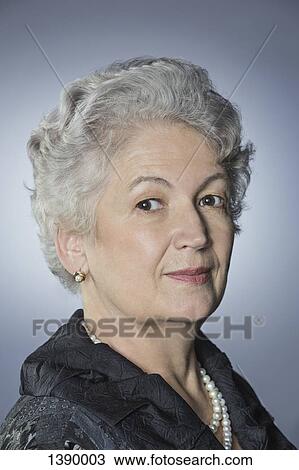 Portrait of confident senior woman over gray background View Large Photo Image Stock Image - Portrait of confident senior woman over gray background. Fotosearch