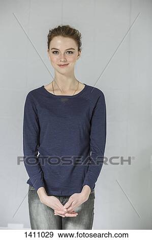Portrait of confident woman standing with hands clasped against white background View Large Photo Image Stock Photo - Portrait of confident woman standing with hands clasped against white background. Fotosearch