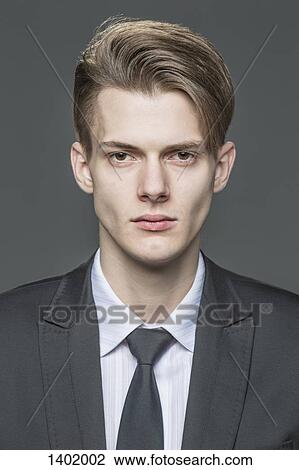 Portrait of confident young businessman over gray background View Large Photo Image Stock Image - Portrait of confident young businessman over gray background. Fotosearch