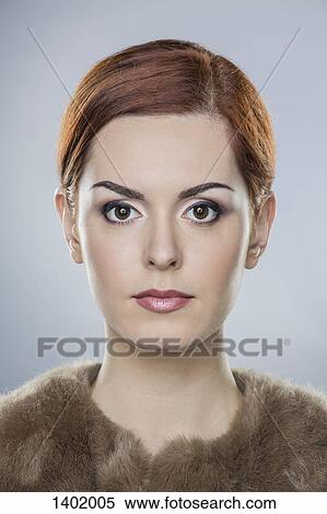 Portrait of confident young woman over gray background View Large Photo Image Stock Photography - Portrait of confident young woman over gray background. Fotosearch