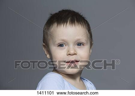 Portrait of cute boy against gray background View Large Photo Image Stock Image - Portrait of cute boy against gray background. Fotosearch