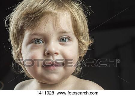 Portrait of cute boy smiling against black background View Large Photo Image Stock Photo - Portrait of cute boy smiling against black background. Fotosearch