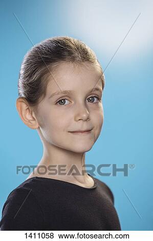 Portrait of cute girl smiling against blue background View Large Photo Image Stock Photo - Portrait of cute girl smiling against blue background. Fotosearch