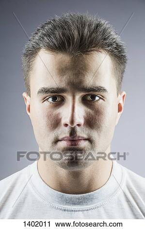 Portrait of handsome young man over gray background View Large Photo Image Stock Image - Portrait of handsome young man over gray background. Fotosearch