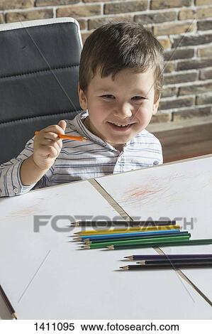 Portrait of happy boy drawing at table in house View Large Photo Image Stock Photography - Portrait of happy boy drawing at table in house. Fotosearch