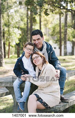 Portrait of happy family sitting on picnic table in forest View Large Photo Image Stock Image - Portrait of happy family sitting on picnic table in forest. Fotosearch