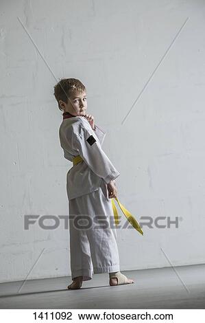 Portrait of karate boy standing against white wall View Large Photo Image Stock Image - Portrait of karate boy standing against white wall. Fotosearch