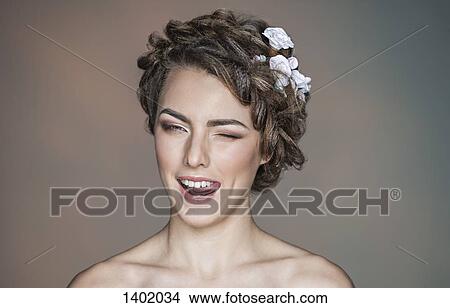 Portrait of playful young woman winking against colored background View Large Photo Image Picture - Portrait of playful young woman winking against colored background. Fotosearch