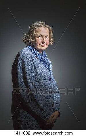 Portrait of senior woman standing with hands clasped against gray background View Large Photo Image Stock Image - Portrait of senior woman standing with hands clasped against gray background. Fotosearch