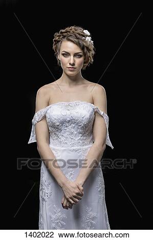 Portrait of serious young bride standing against black background View Large Photo Image Stock Image - Portrait of serious young bride standing against black background. Fotosearch