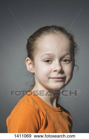 Stock Photo - Portrait of smiling girl against gray background. Fotosearch