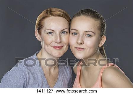 Portrait of smiling mother and daughter against gray background View Large Photo Image Stock Photo - Portrait of smiling mother and daughter against gray background. Fotosearch