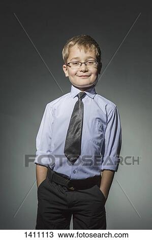 Portrait of well-dressed boy standing against gray background View Large Photo Image Stock Image - Portrait of well-dressed boy standing against gray background. Fotosearch