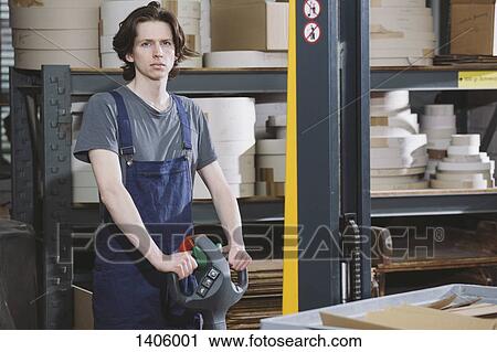 Portrait of young male worker working in warehouse View Large Photo Image Stock Image - Portrait of young male worker working in warehouse. Fotosearch